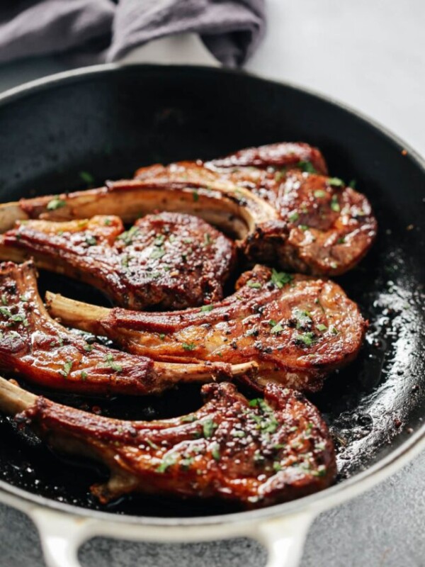 overhead view of a white skillet containing lamb chops