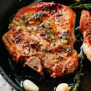 closeup pork chops in a cast iron skillet