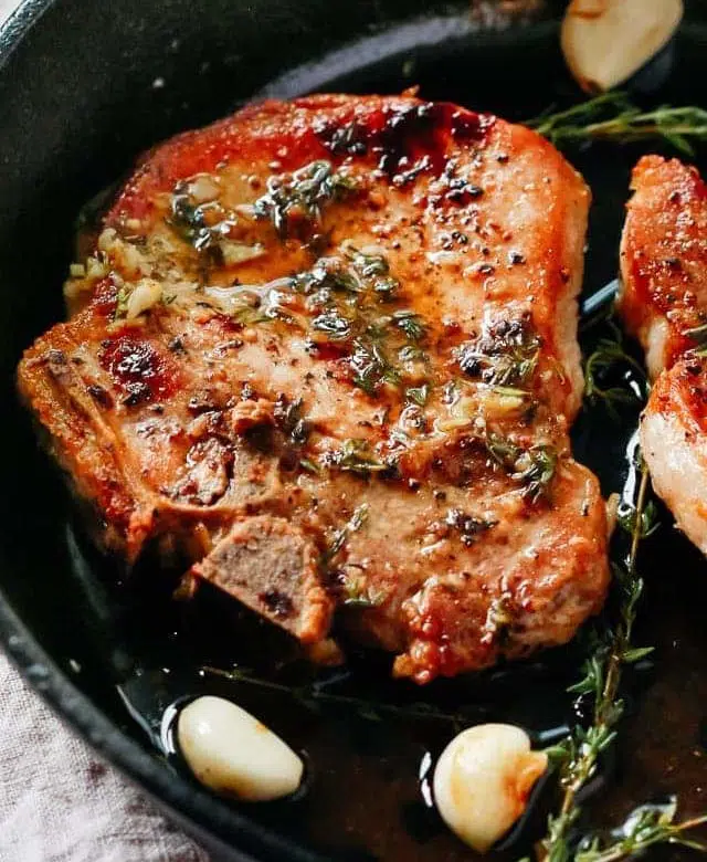 closeup pork chops in a cast iron skillet