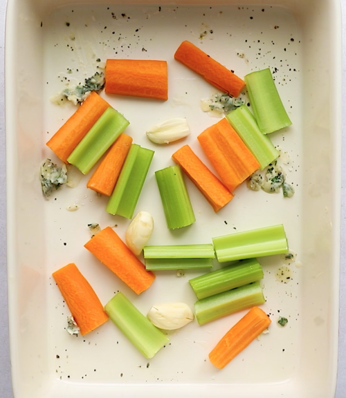 overhead view of carrots and celery in a baking pan