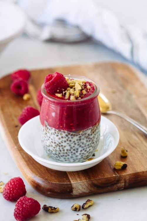 A jar of chia seed pudding with raspberry puree on top.