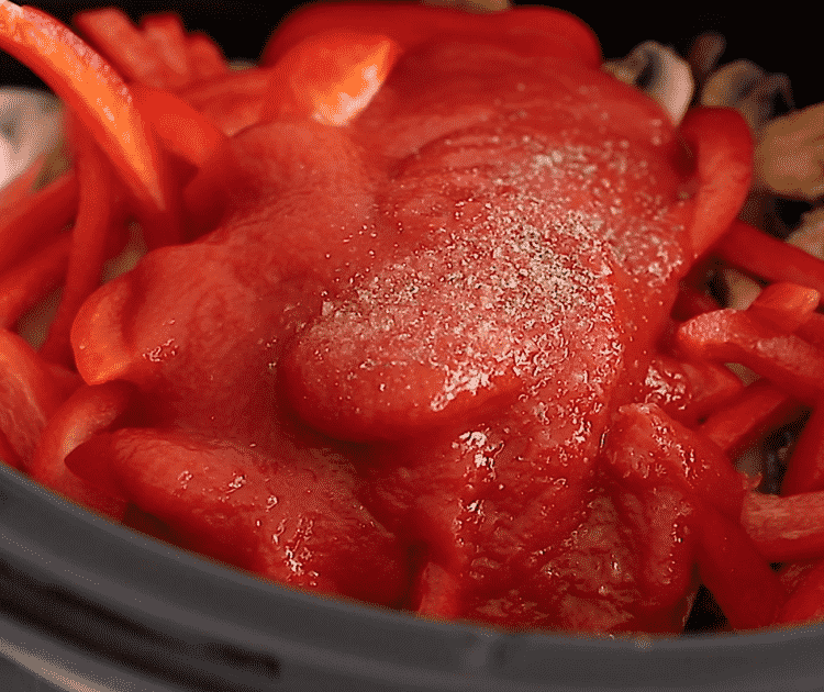 closeup view of Italian sausage and bell peppers in a slow cooker bowl