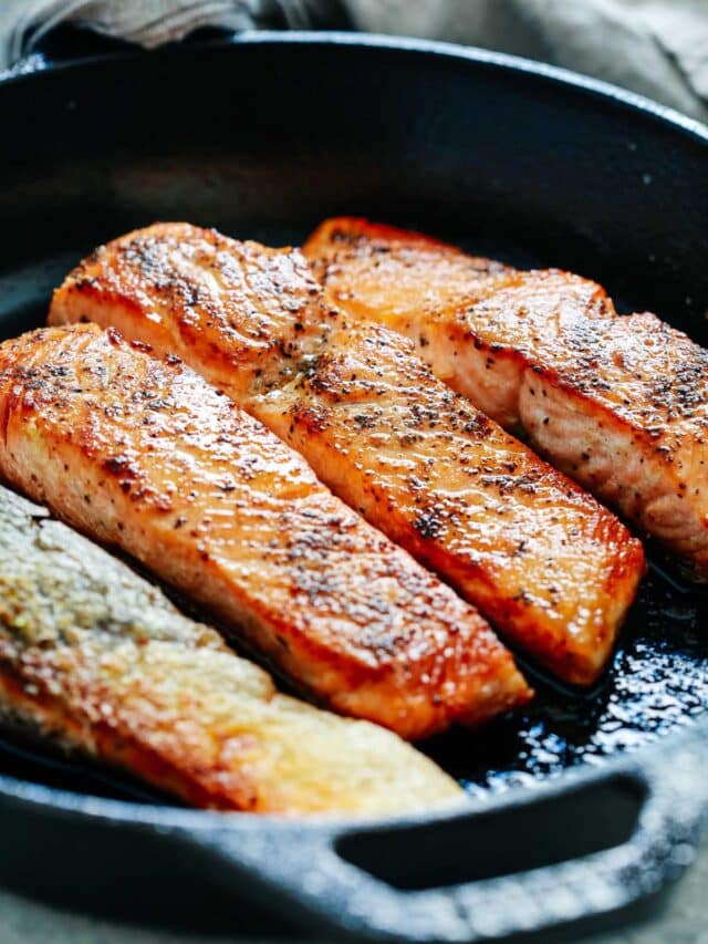 closeup of pan seared salmon in a cast iron skillet