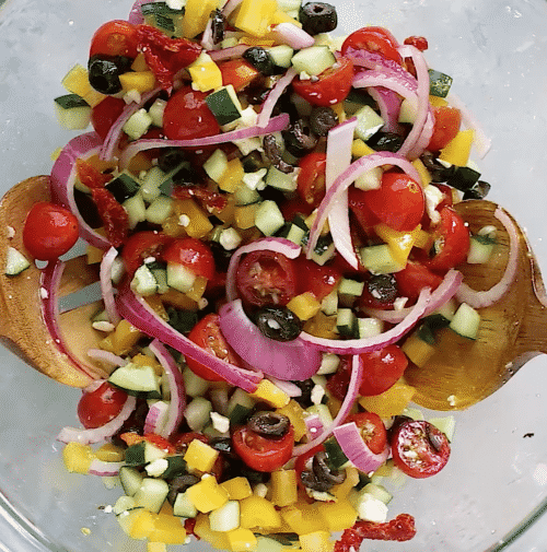 overhead view of a glass bowl containing mediterranean salad