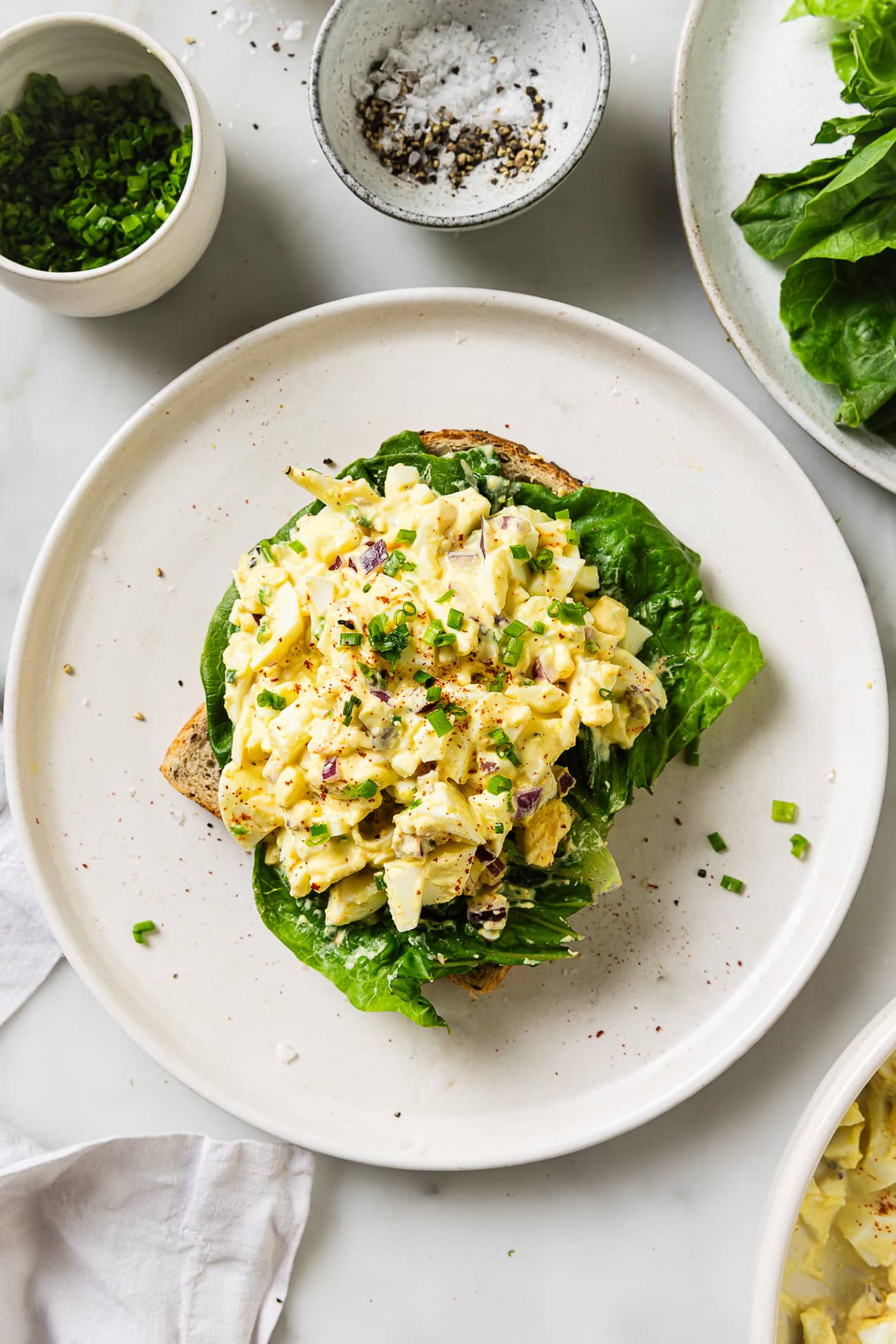 egg salad on a white plate on a marble countertop