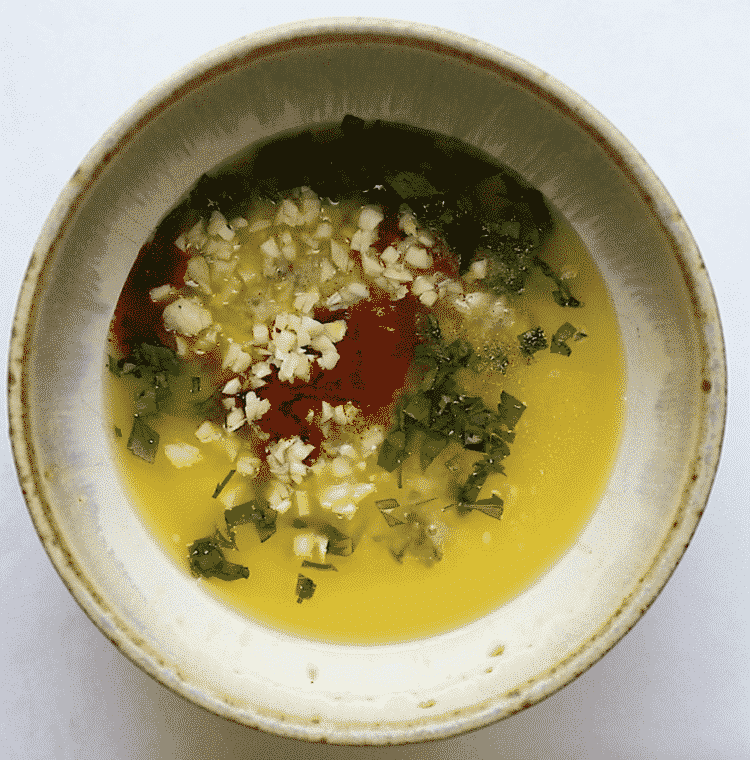 overhead shot of a small bowl with melted butter and spices