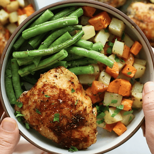 overhead view of a bowl containing chicken and vegetables