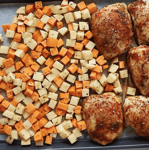 overhead view of diced potatoes and chicken things on a baking sheet