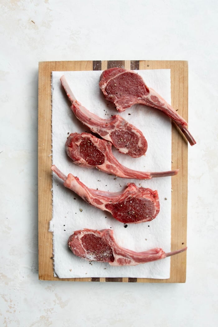 raw lamb chops on a wooden board