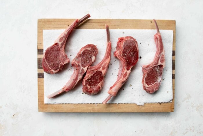 raw lamb chops on a wooden board