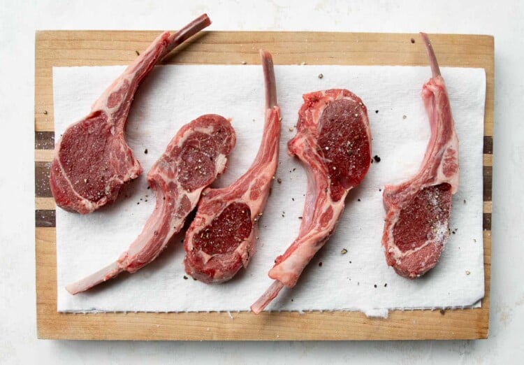 raw lamb chops on a wooden board