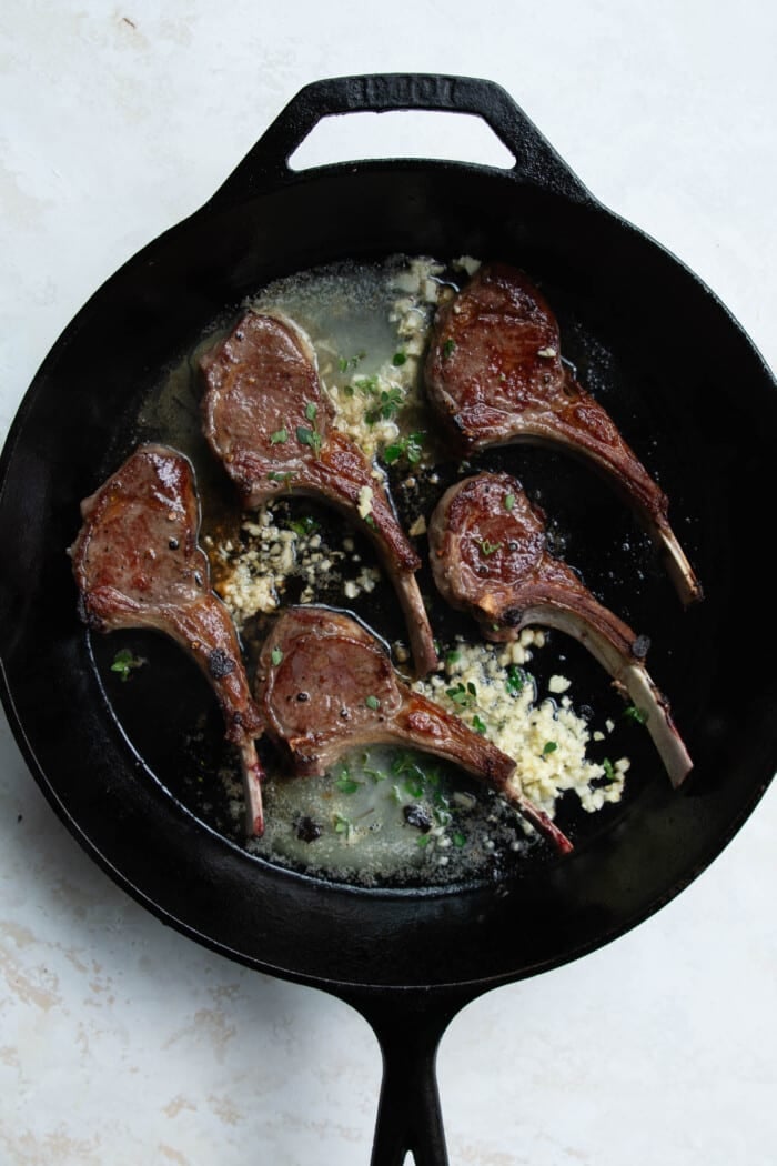 lamb chops in a skillet with butter and garlic