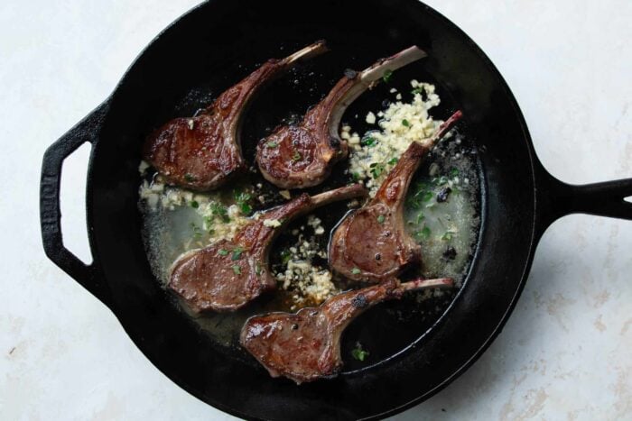 lamb chops in a skillet with butter and garlic