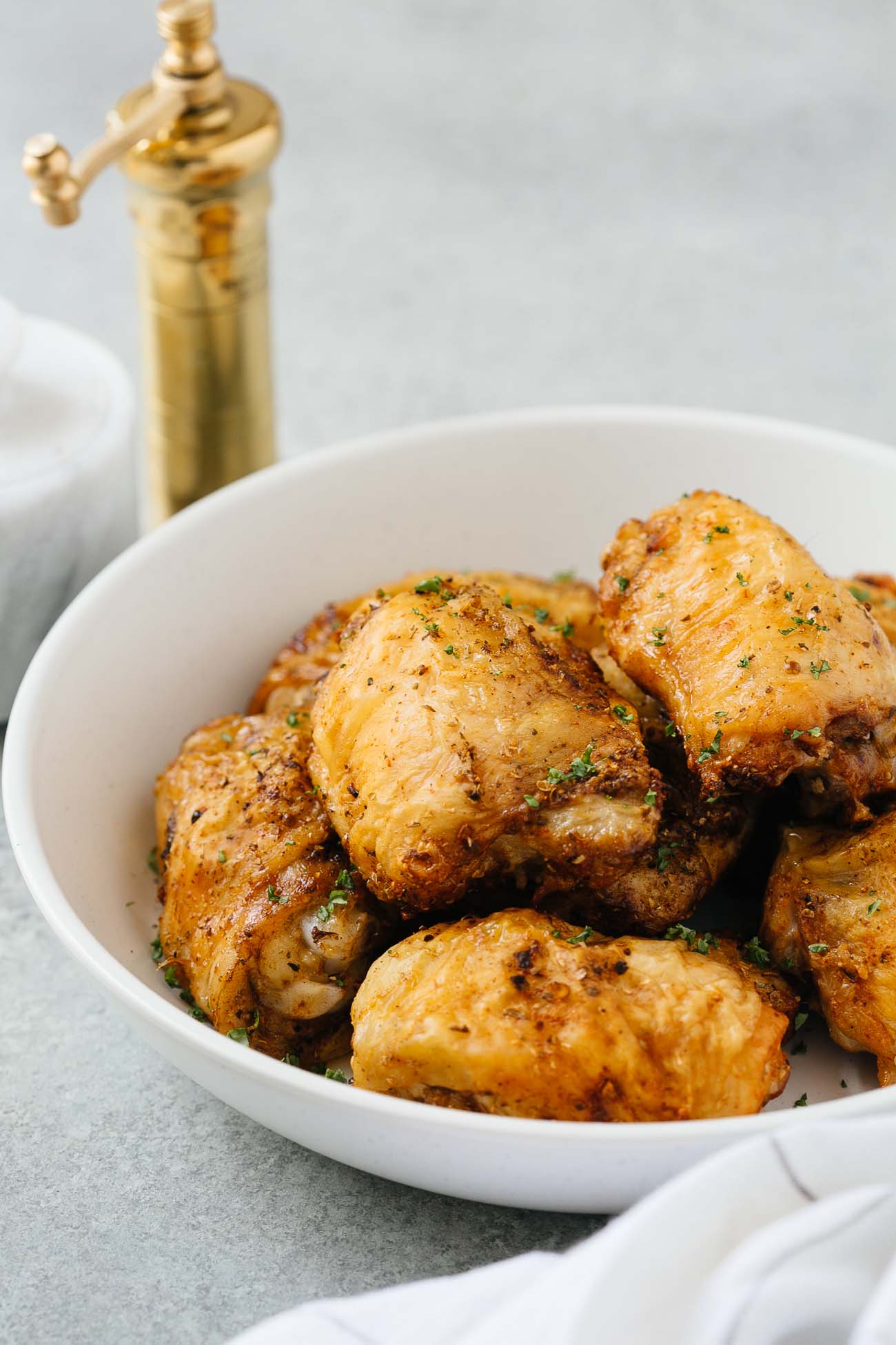 A white bowl with air fryer chicken thighs.