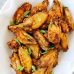 overhead view of a white plate containing cooked chicken wings
