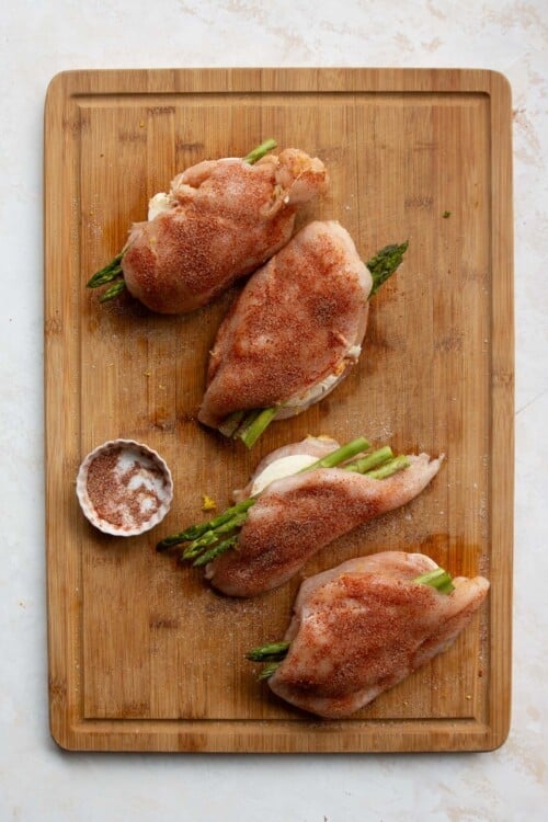 seasoned chicken breasts on a wooden board.