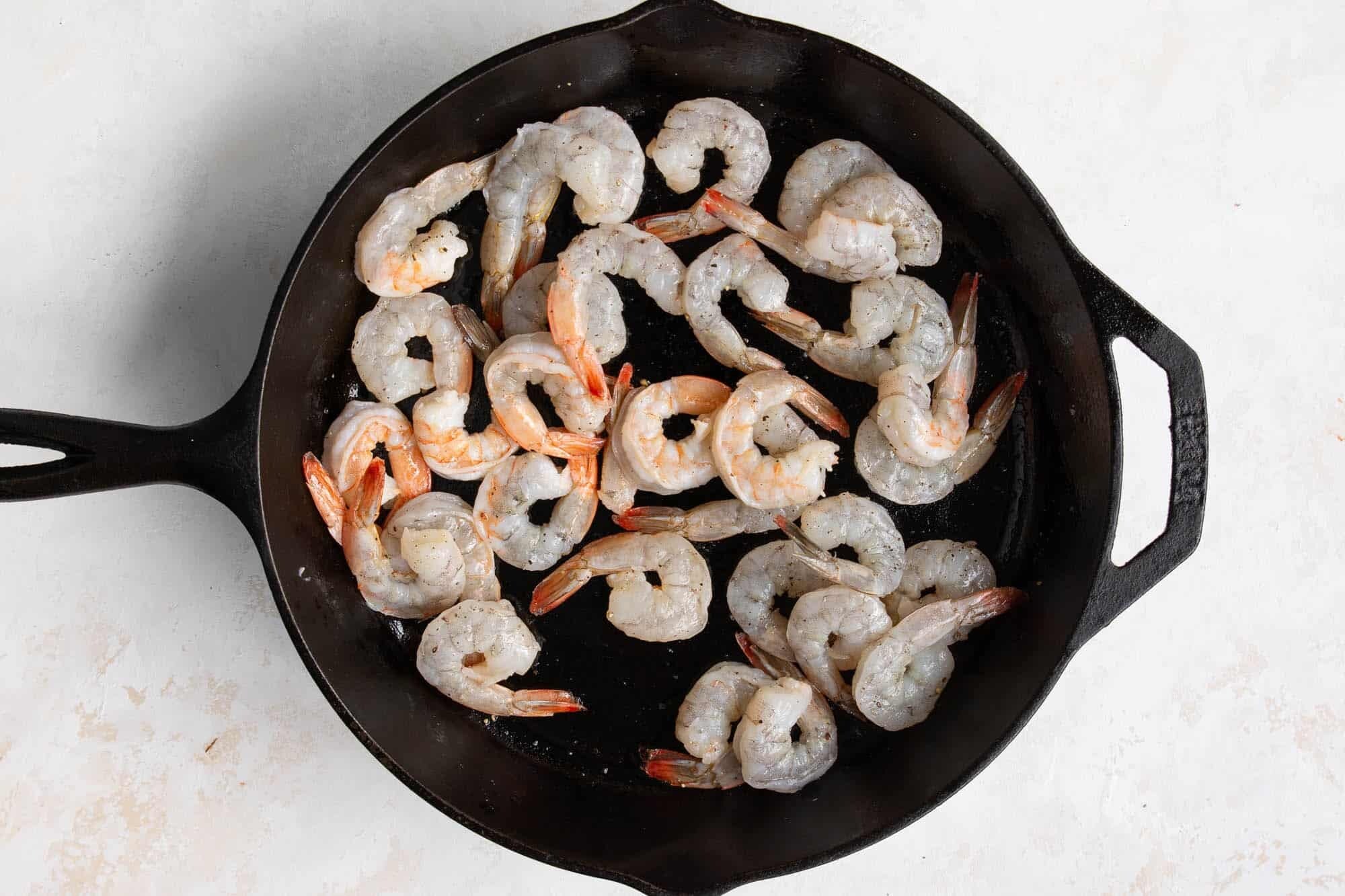 raw shrimp in a cast iron skillet