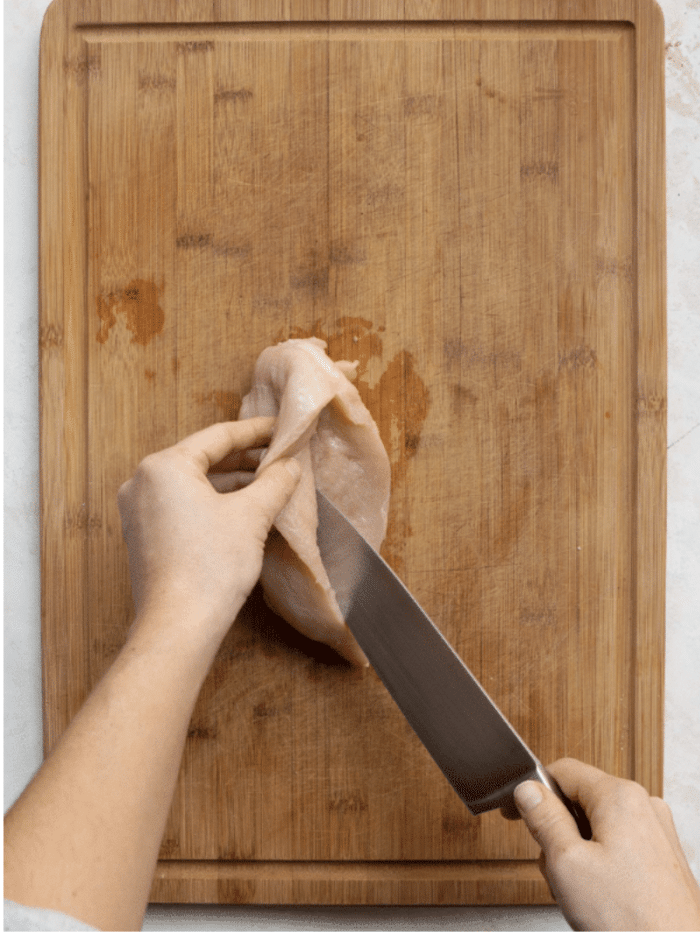 chicken breast getting cut in half lengthwise