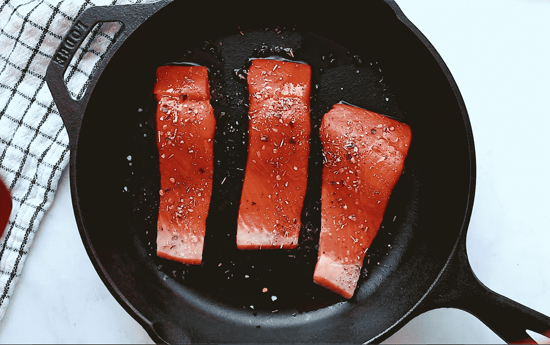 overhead view of a cast iron skillet containing salmon