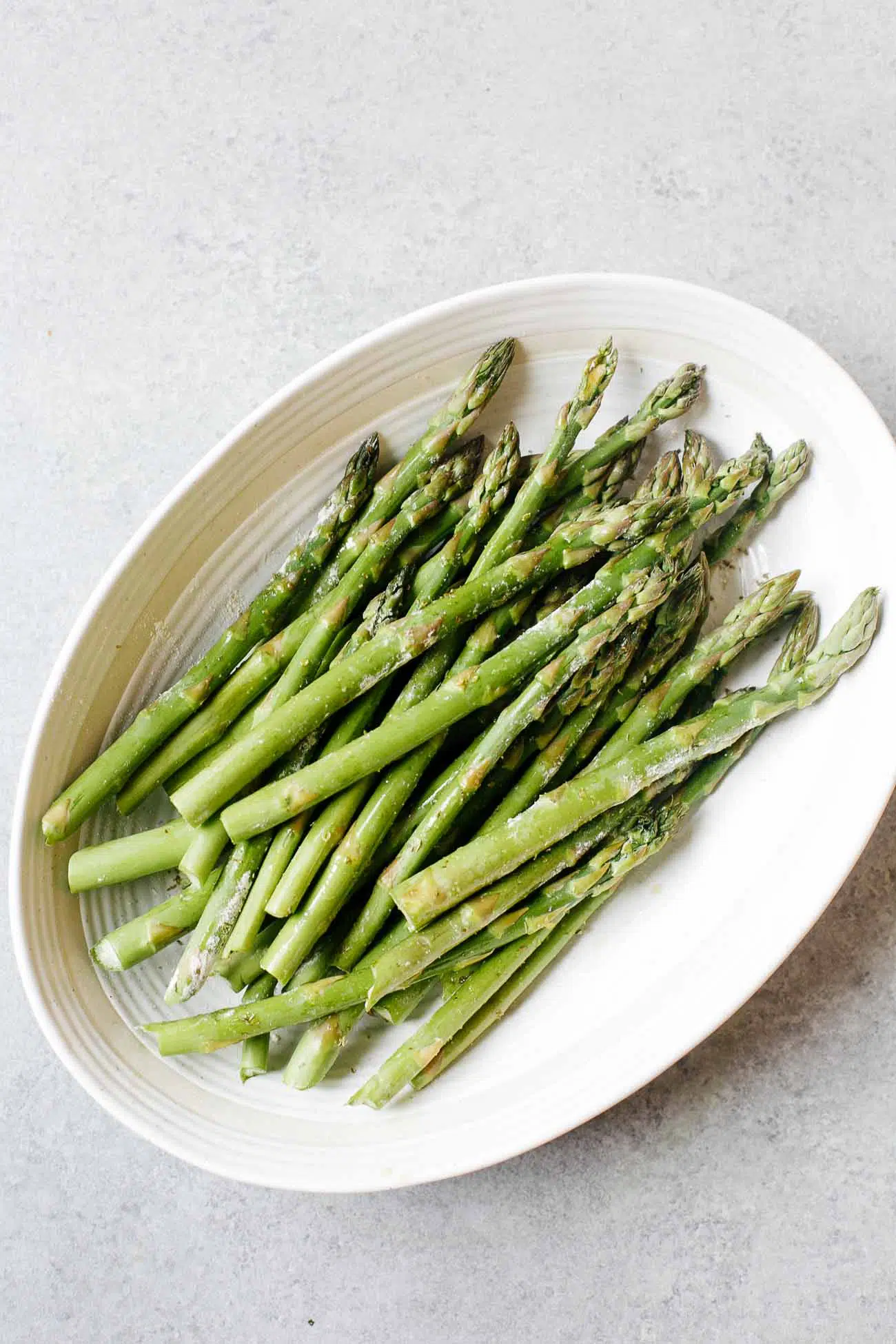 overhead view of asparagus in a casserole white dish