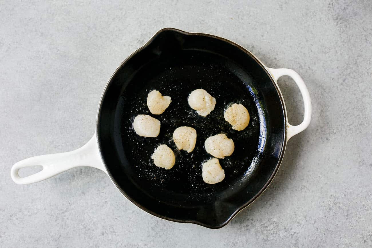 Scallops in a cast iron pan.