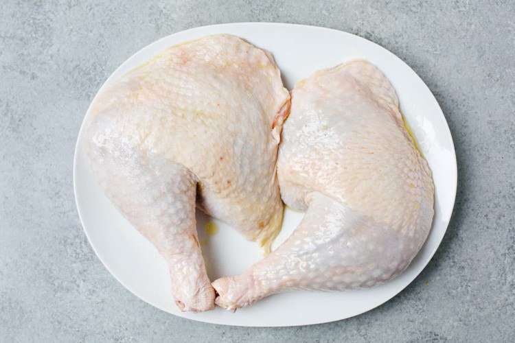 raw turkey leg on a white plate