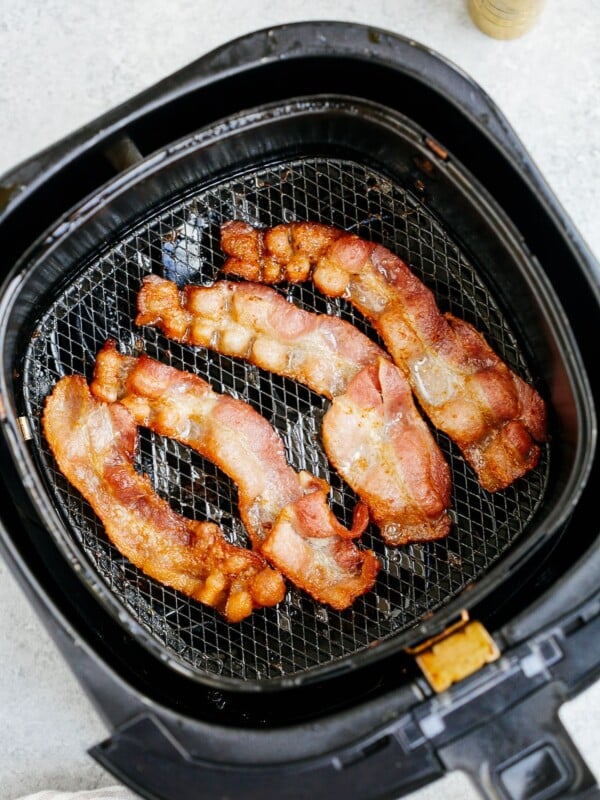 overhead view of cooked bacon inside of a air fryer basket