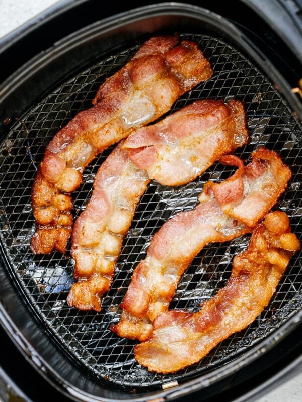overhead view of cooked bacon inside of a air fryer basket