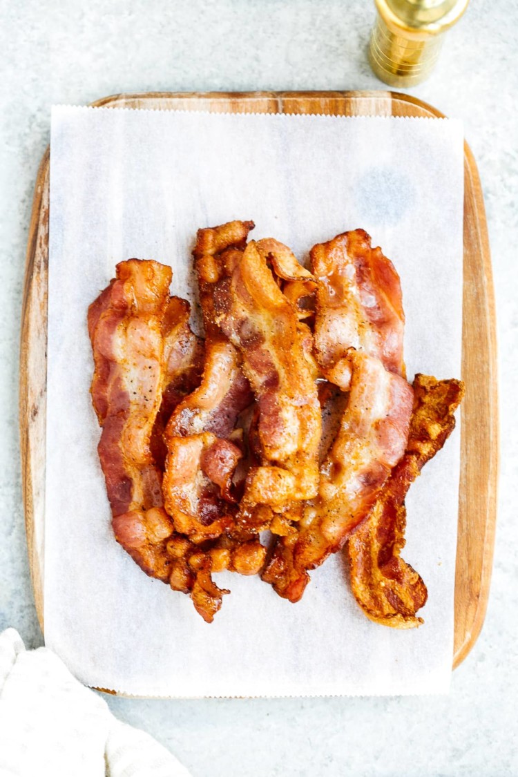 overhead view of cooked bacon on a white surface