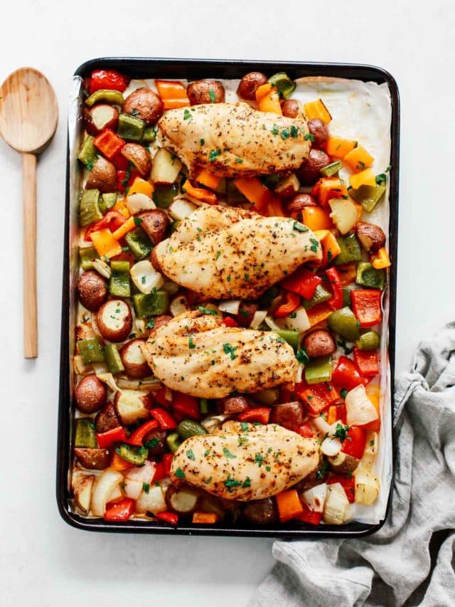 overhead view of chicken breast with veggies in a baking sheet