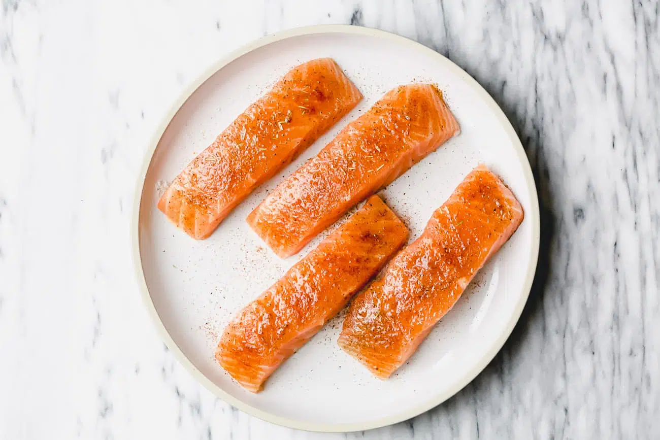 overhead view of white plate containing raw salmon