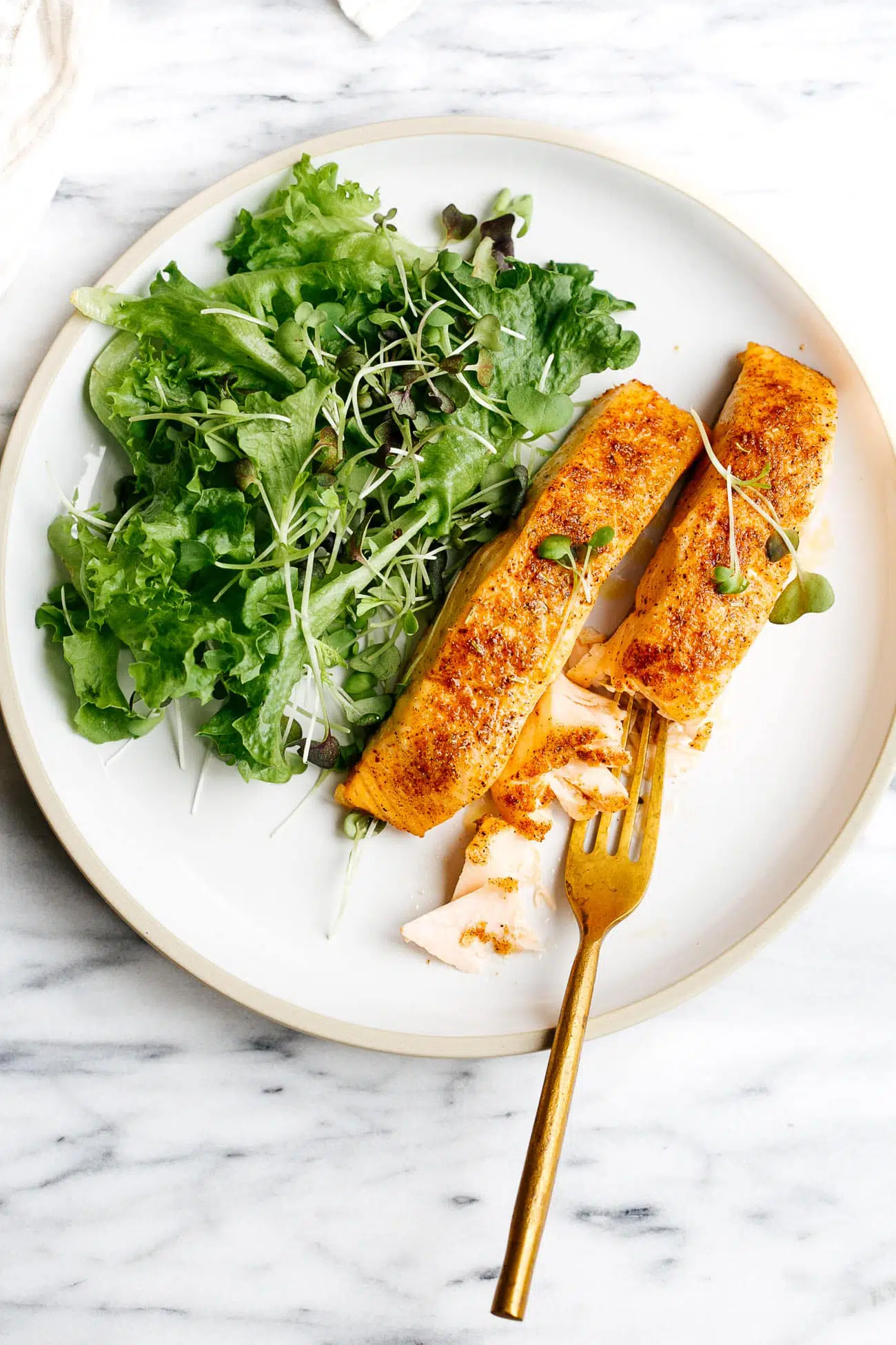 overhead view of white plate containing air fryer salmon 