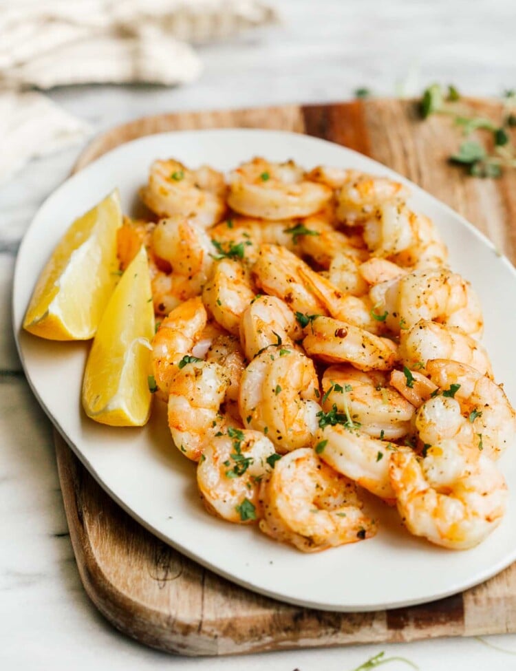 overhead view of a white plate containing cooked shrimp