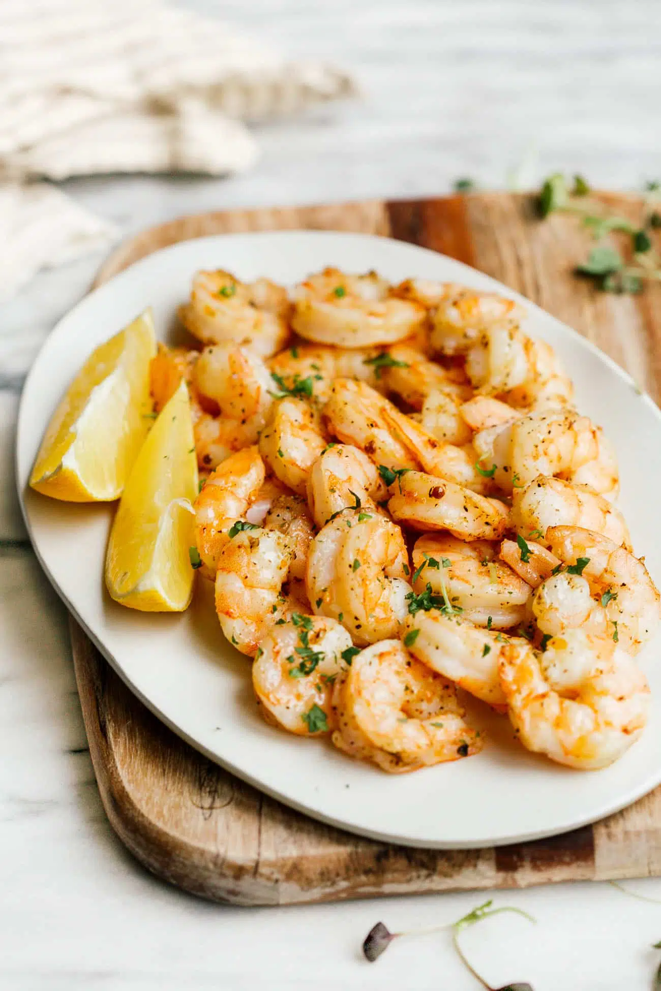 overhead view of a white plate containing cooked air fryer shrimp