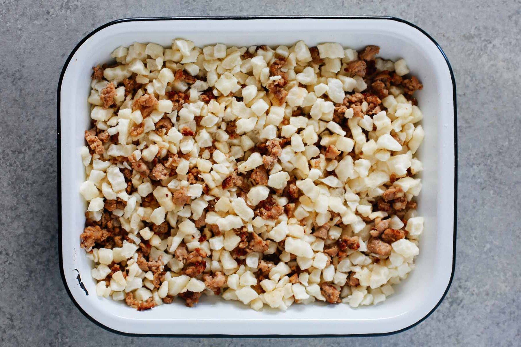 Overhead view of sausage and potato casserole in a baking dish.
