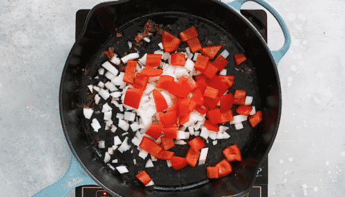 overhead view of a cast iron skillet with veggies inside of it.