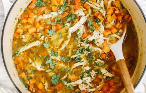 overhead view of sweet potato chicken soup in a dutch oven pot