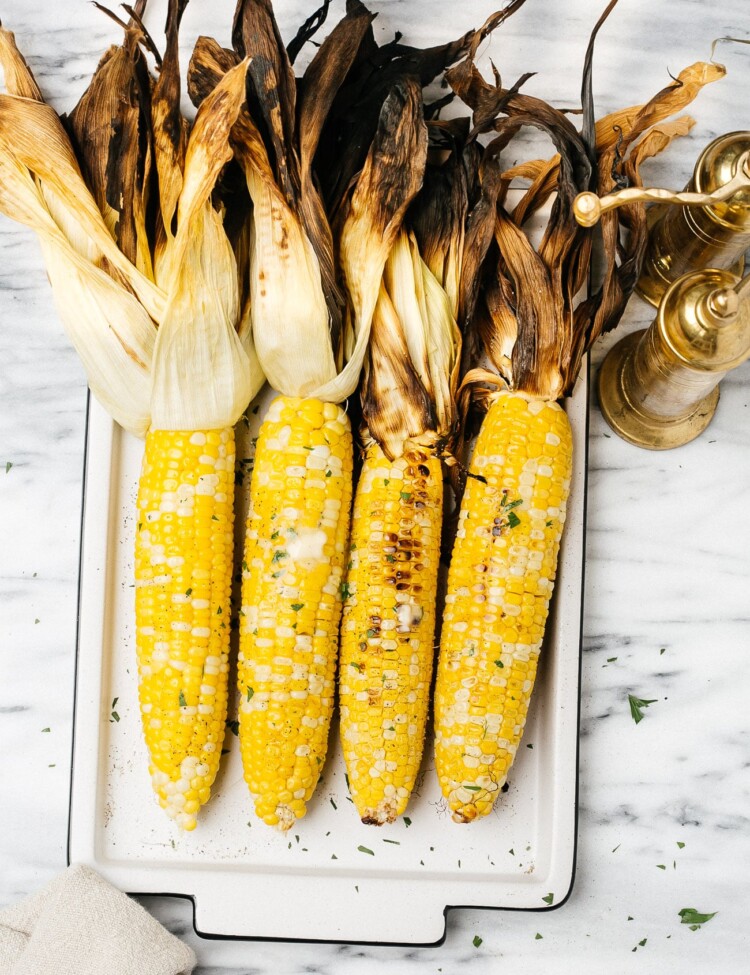 grilled corn on a cob on a white plate