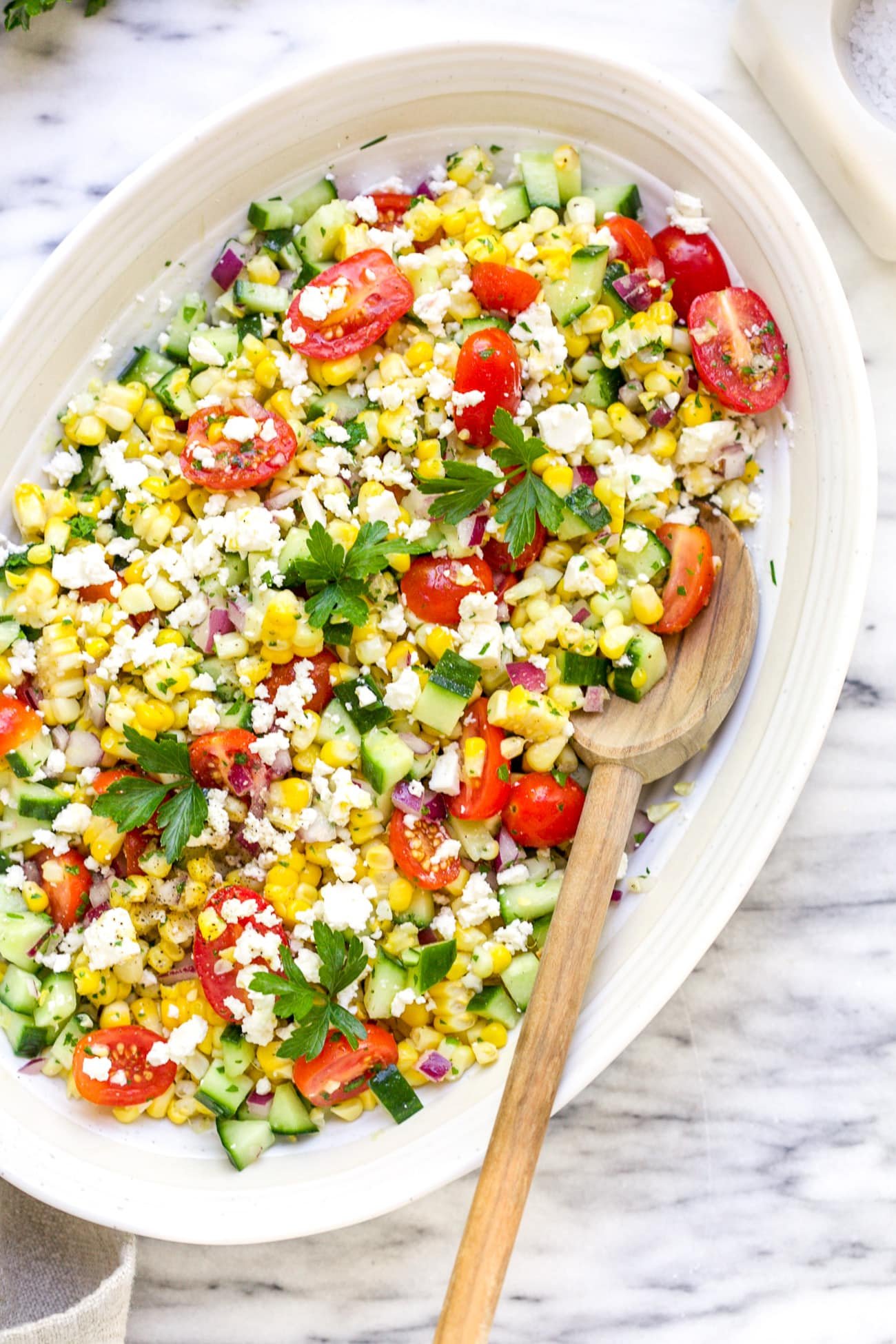 overhead view of corn salad in a white bowl.