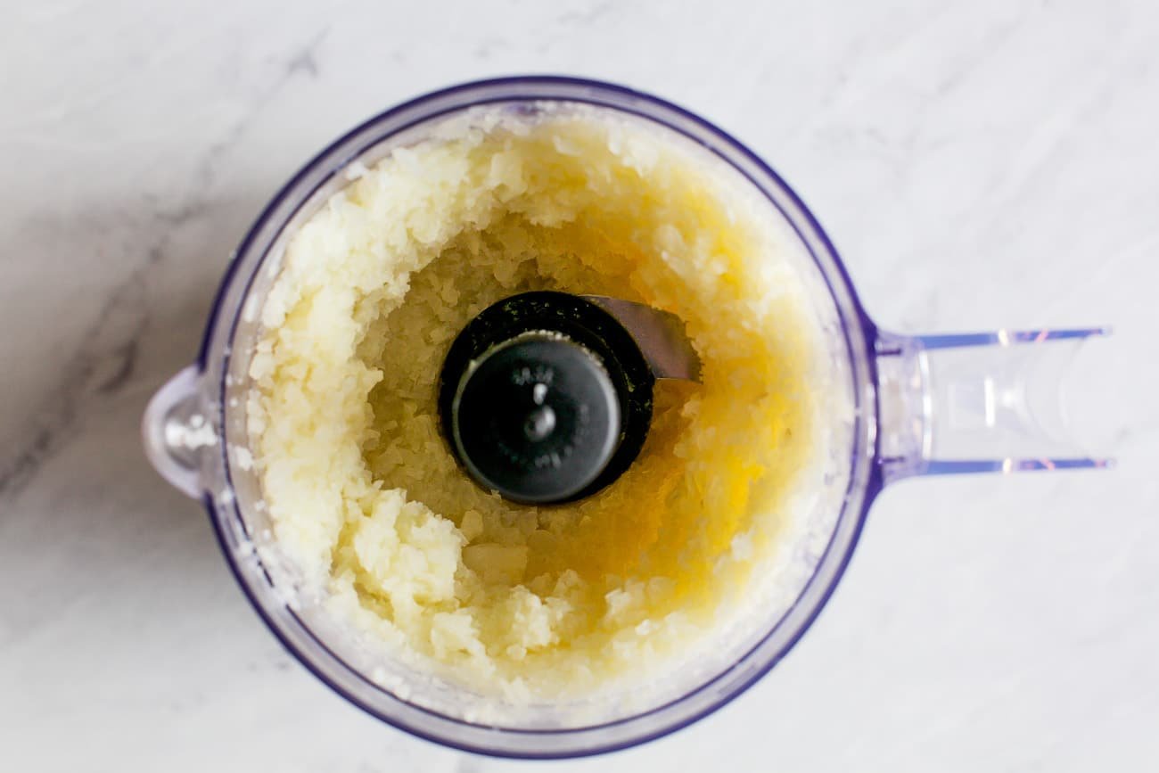 overhead view of cauliflower in a food processor