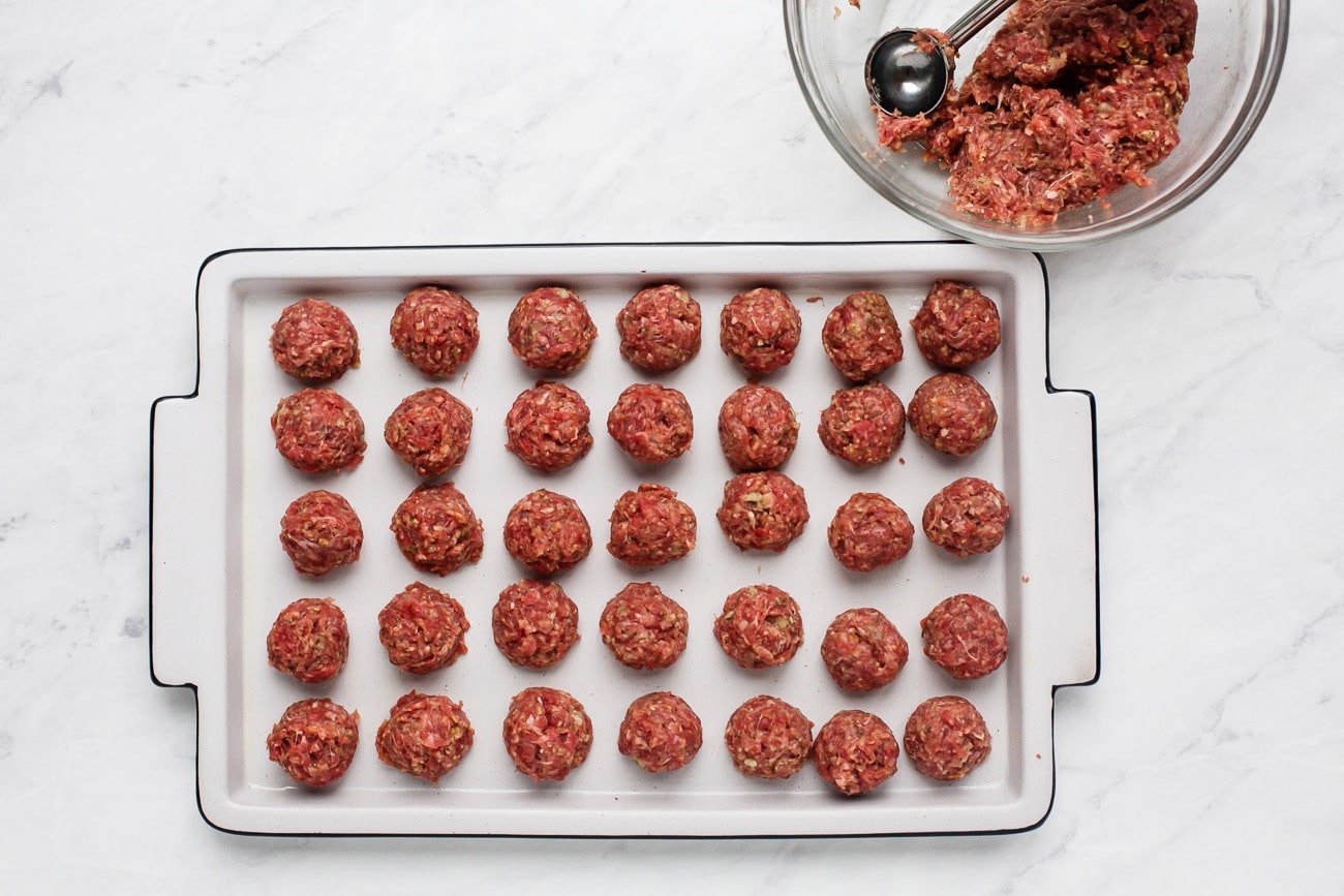 raw meatballs in a baking sheet