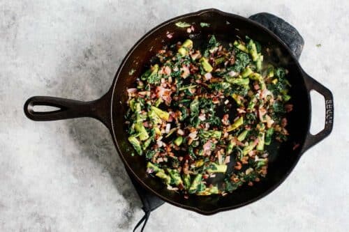 Overhead view of vegetables in an iron skillet.