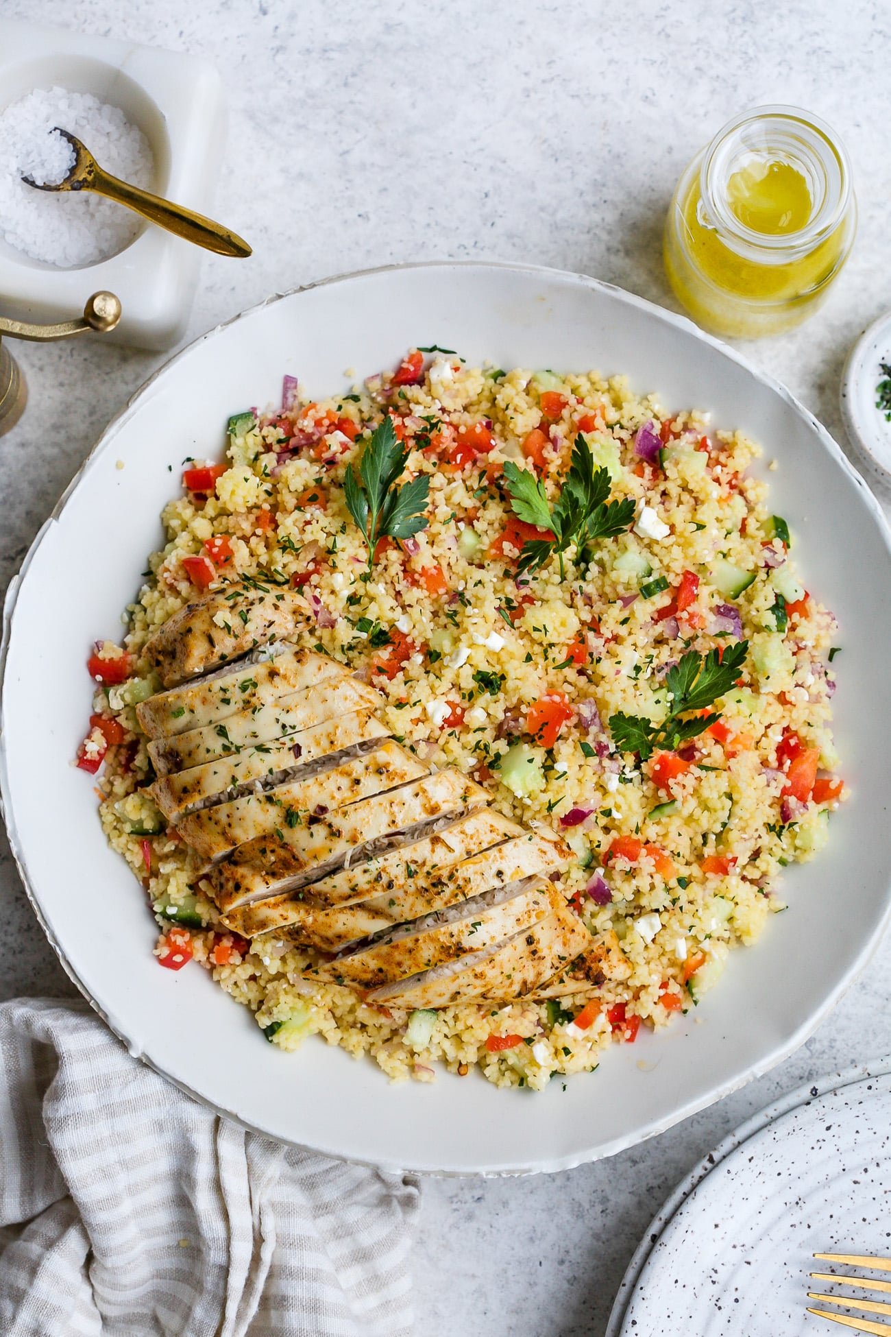 Chicken couscous salad in a large, white serving bowl.
