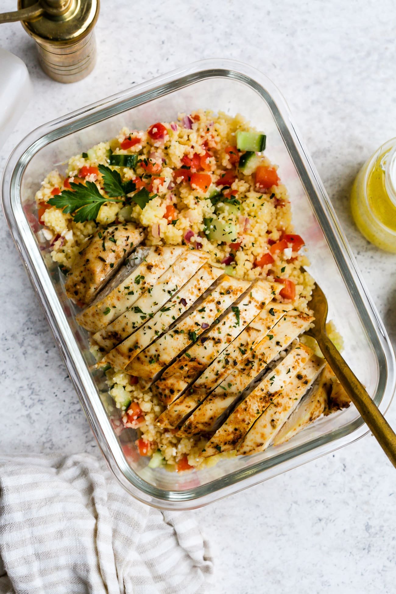 Salad portioned into glass meal prep container.