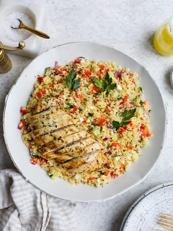 Chicken couscous salad in a large, white serving bowl.
