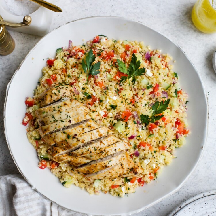 Chicken couscous salad in a large, white serving bowl.