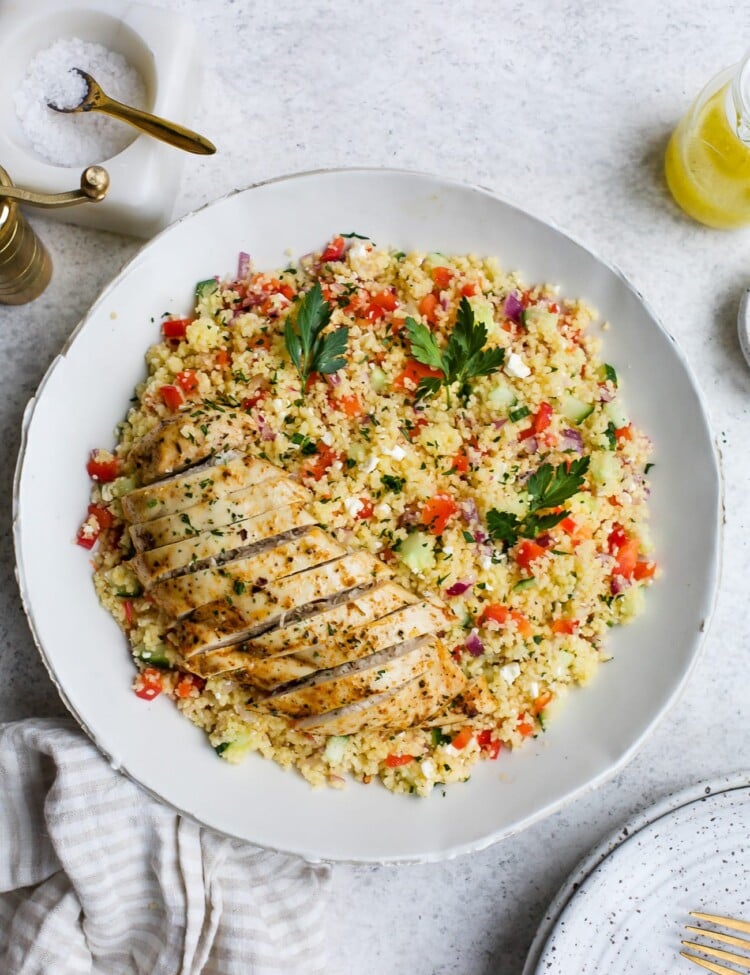 Chicken couscous salad in a large, white serving bowl.