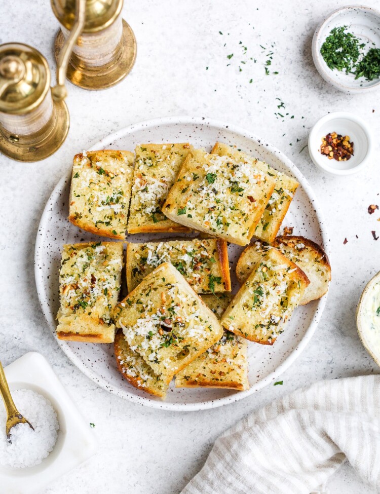 Pieces of garlic bread on a white serving plate.