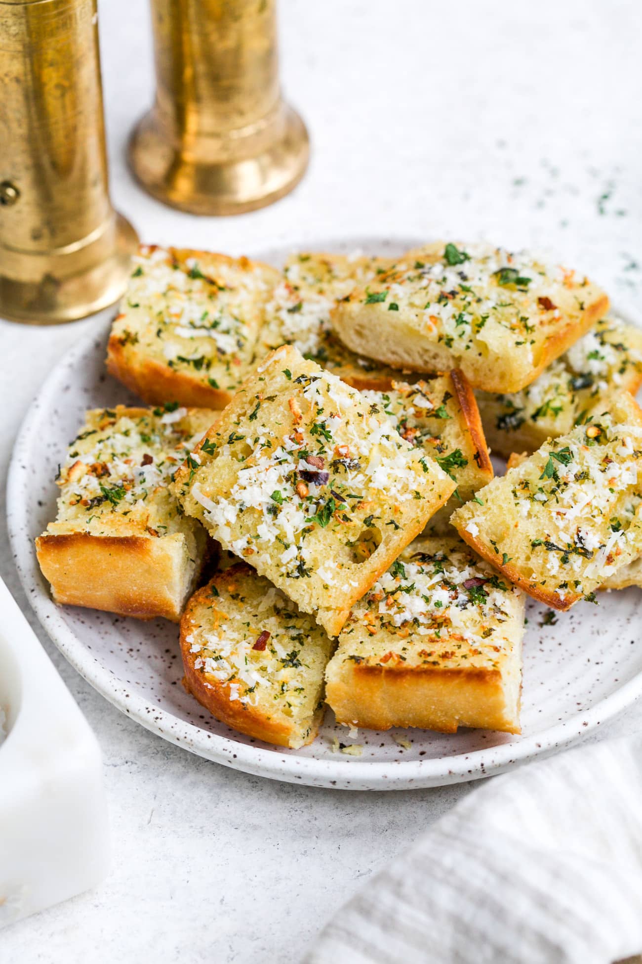 Pieces of garlic bread on a white serving plate.