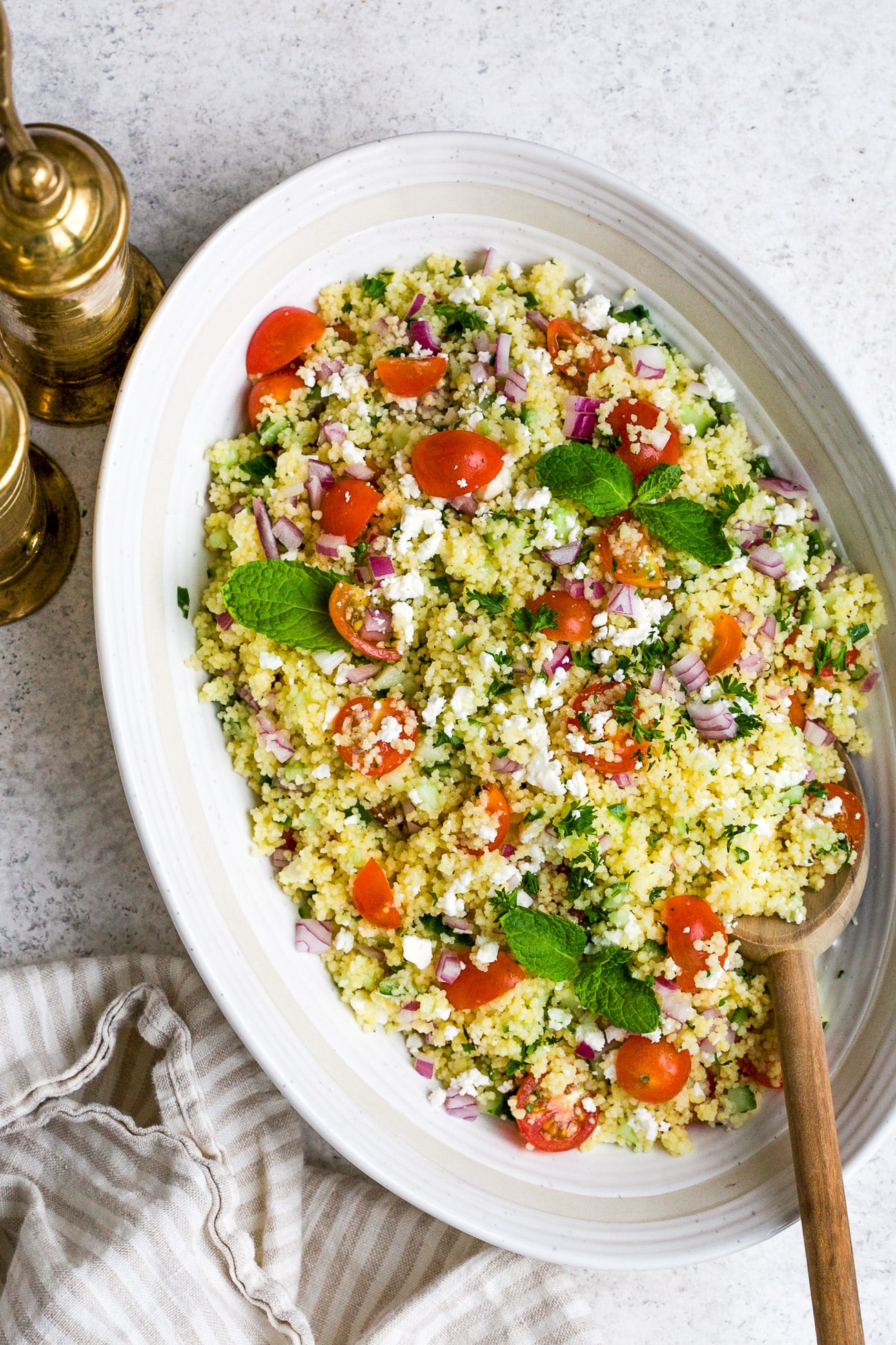 closeup of couscous salad in a white bowl.